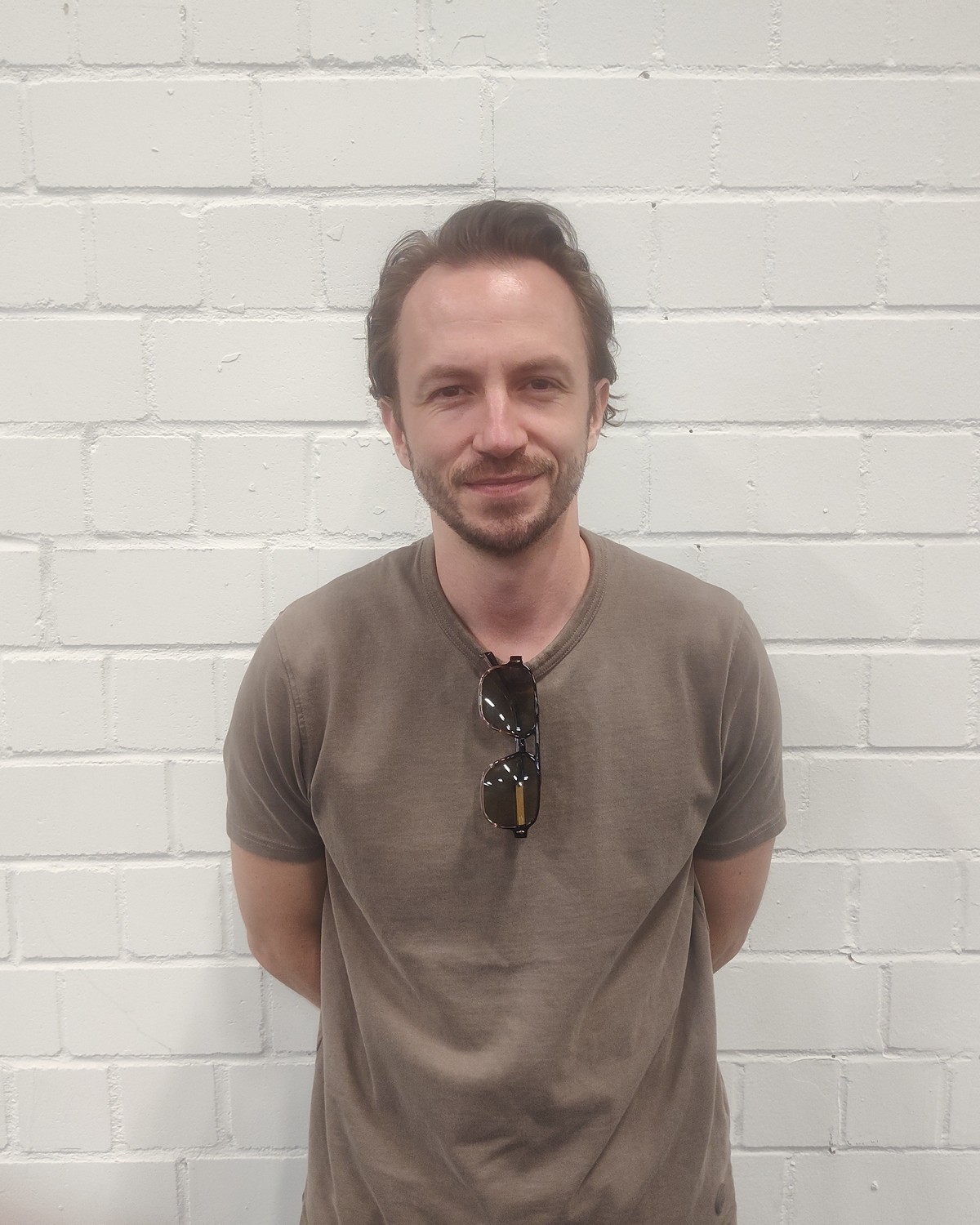 Alex Jordan at Gamescom 2026, standing against a white brick wall