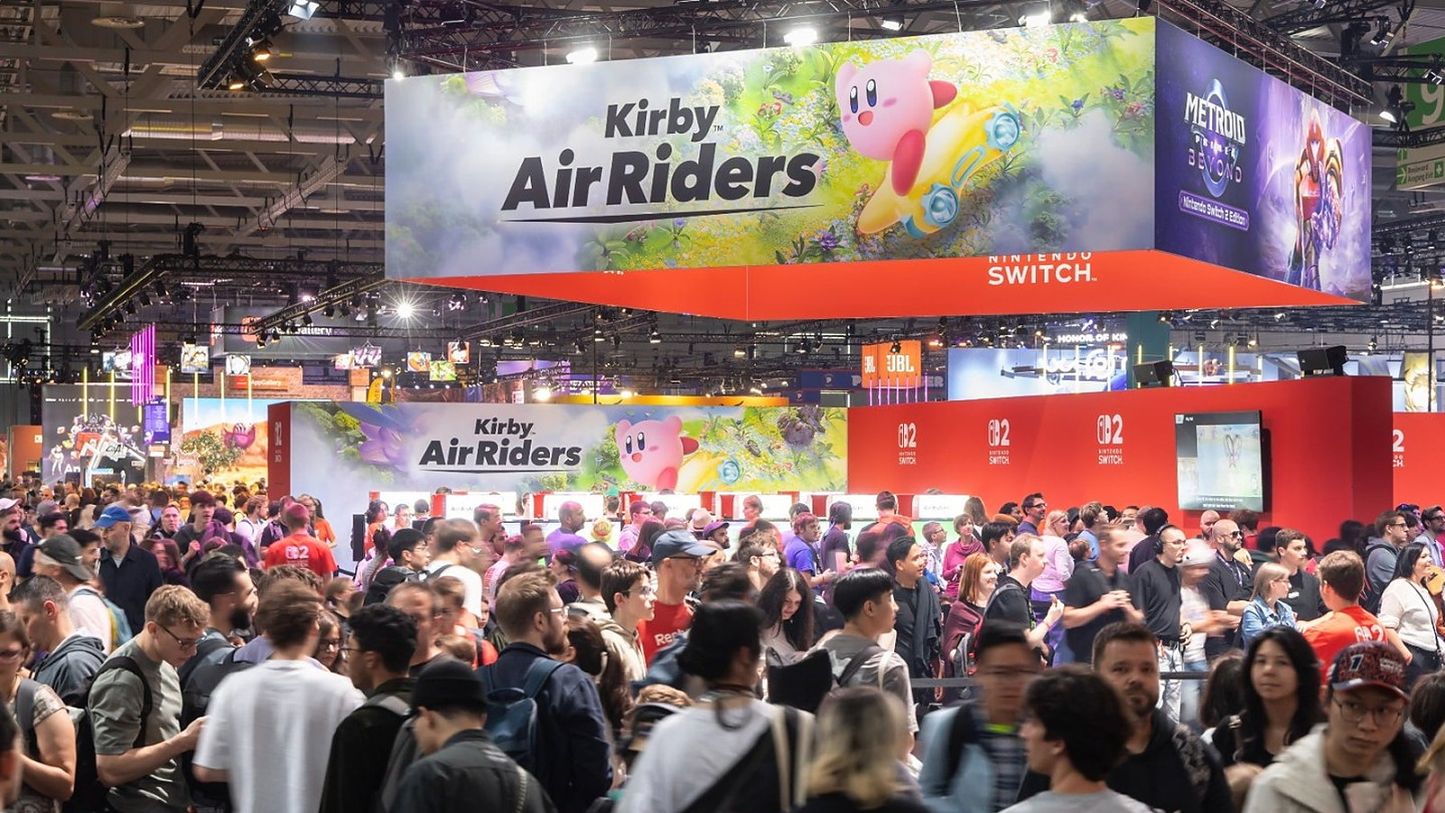 A packed Gamescom exhibition hall beneath enormous Kirby Air Riders and Nintendo Switch 2 displays