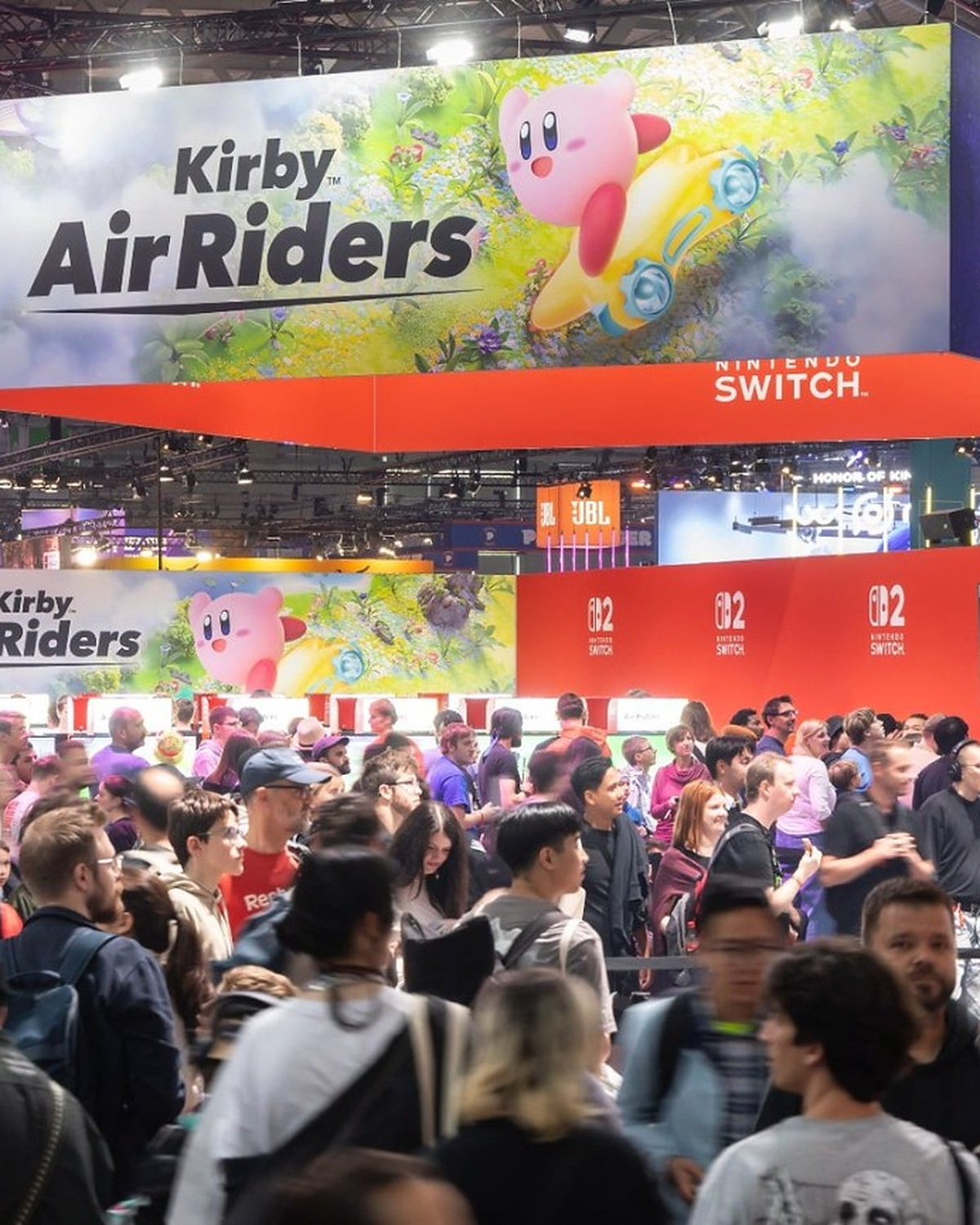 A packed Gamescom exhibition hall beneath enormous Kirby Air Riders and Nintendo Switch 2 displays